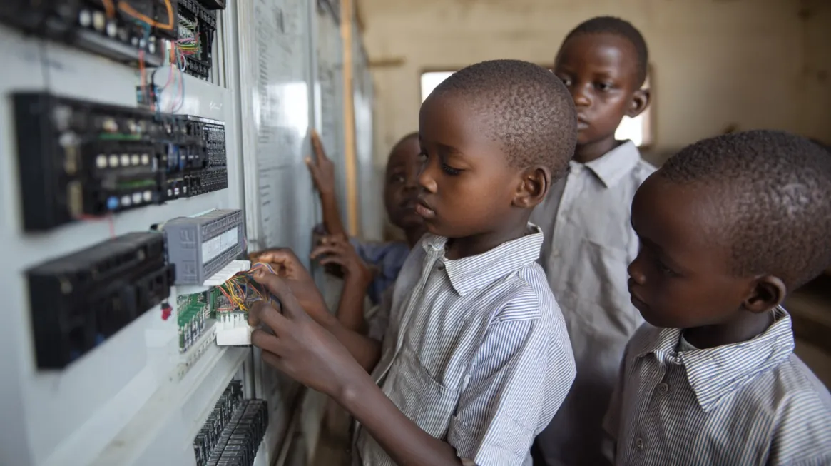 How Reliable Power Transforms Rural Health and Education in Africa 22 Group of African children learning electronics and wiring in a classroom